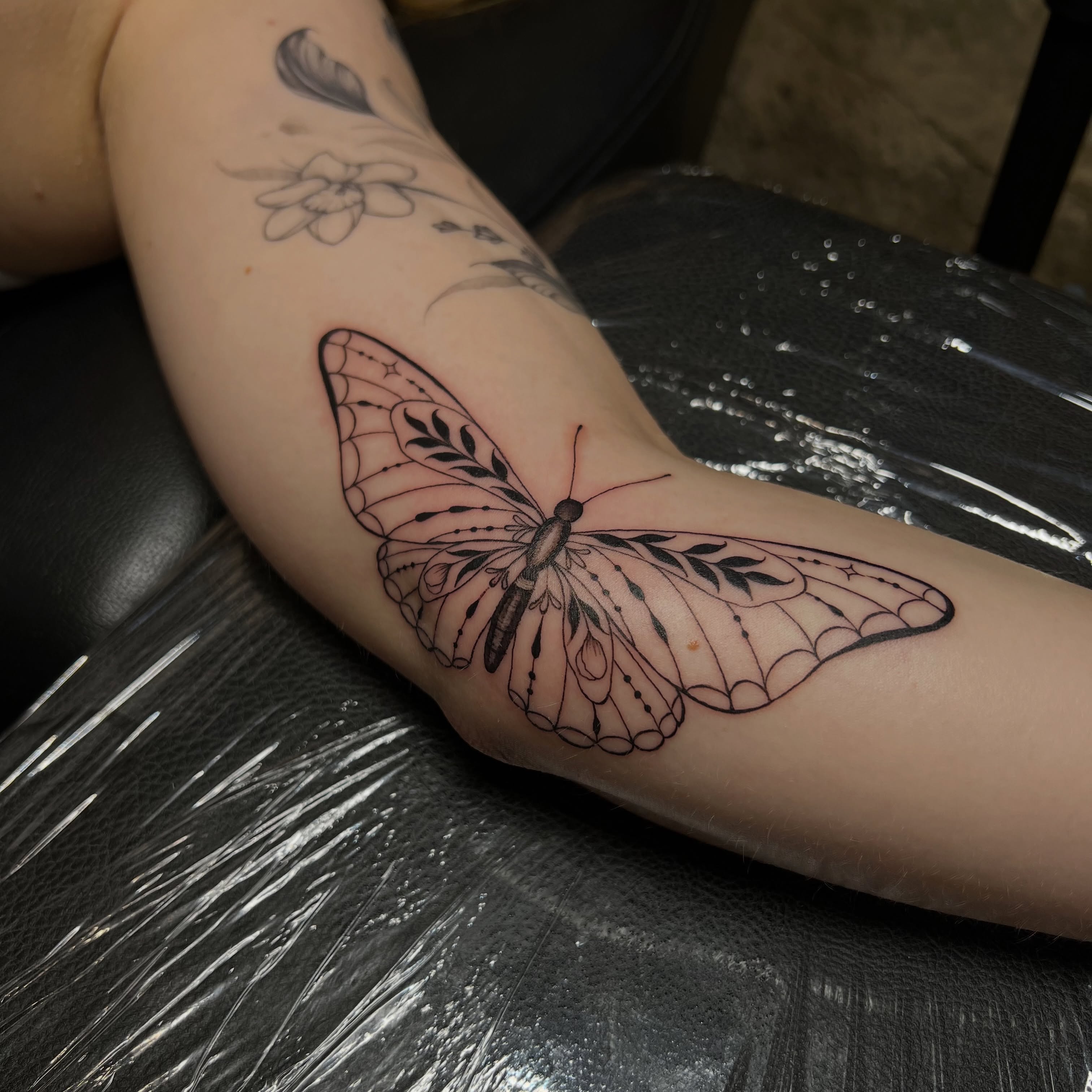 Fine line butterfly tattoo by Clancy Murphy