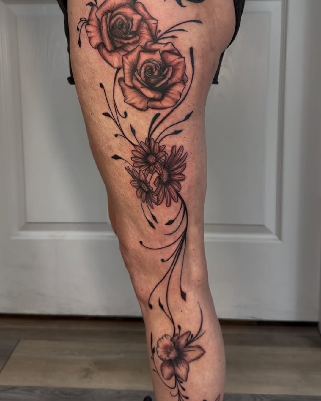 Floral leg piece tattoo by Melissa Angel