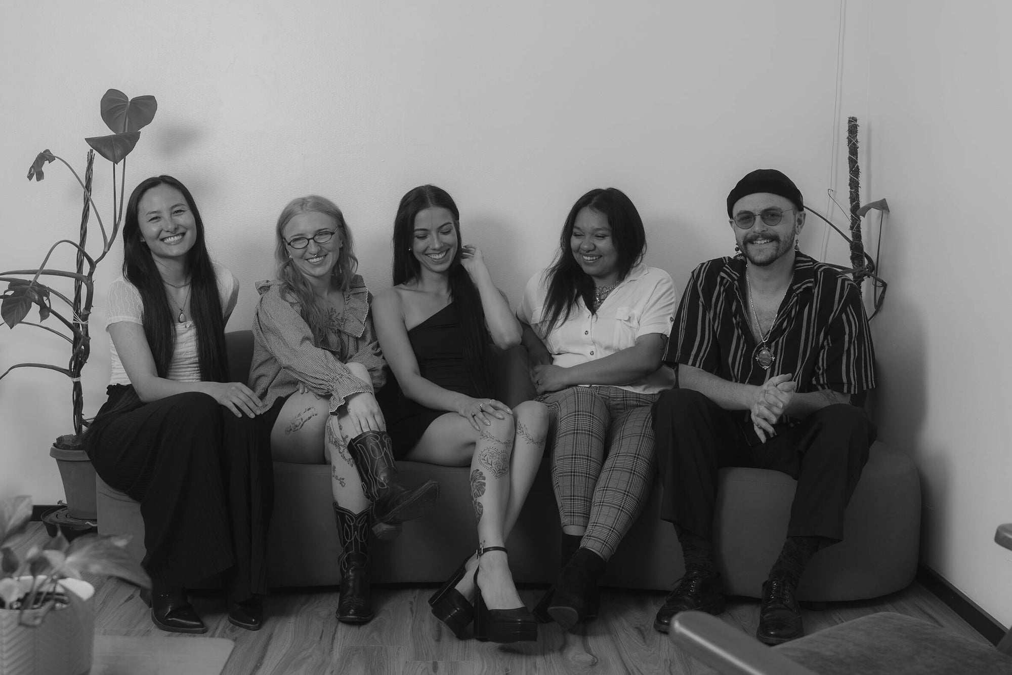 The Studio Nine team sitting together in the studio’s plant-filled seating area